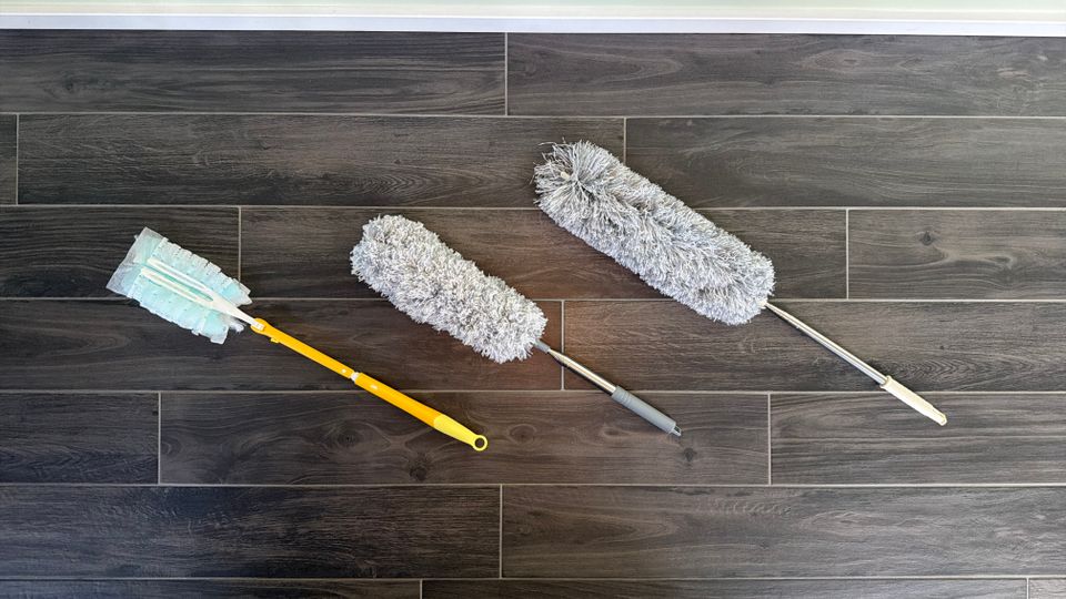 Drei Staubwedel liegen nebeneinander auf einem Fliesenboden.