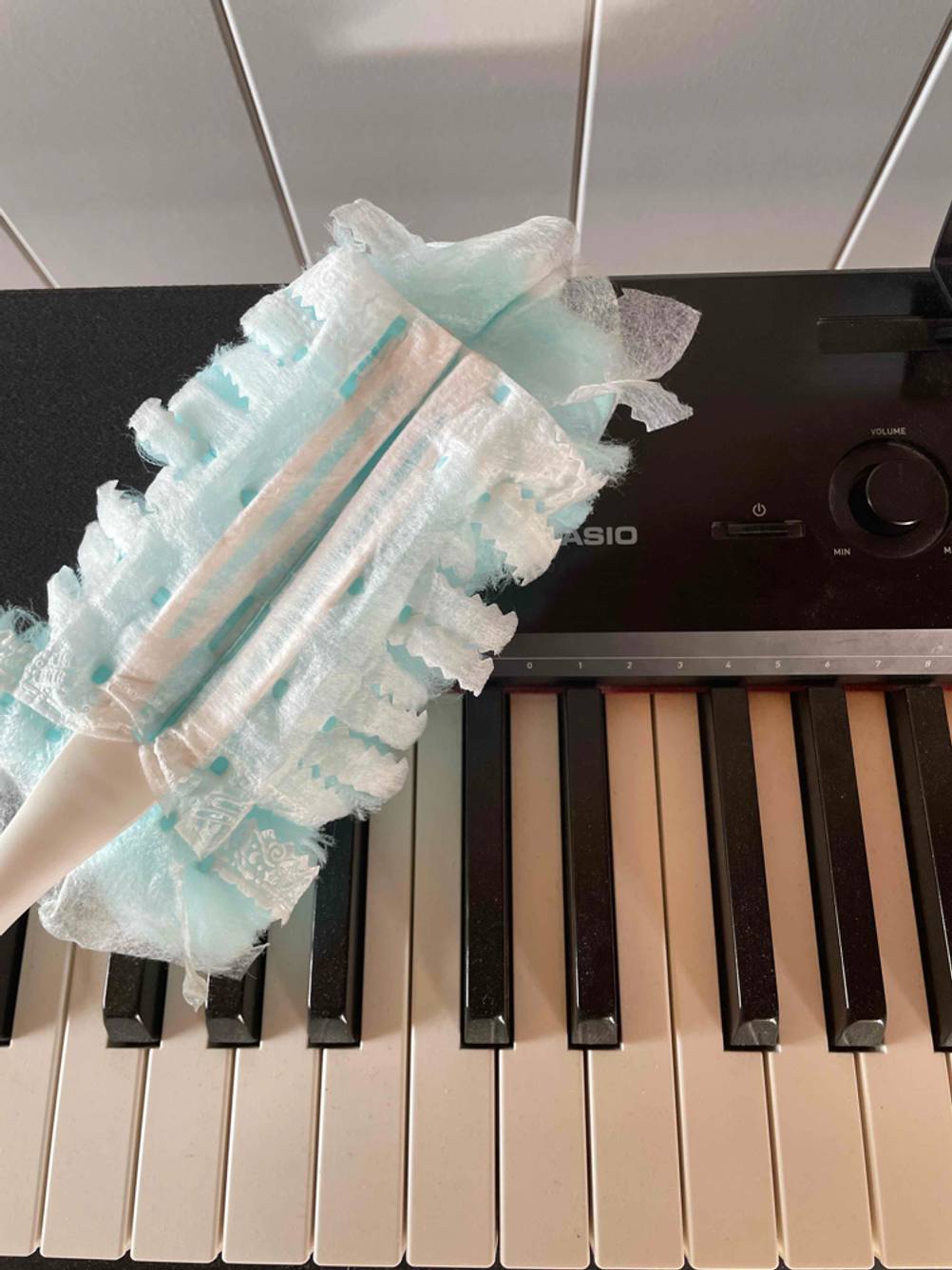Klavier wird mit Staubwedel gereinigt