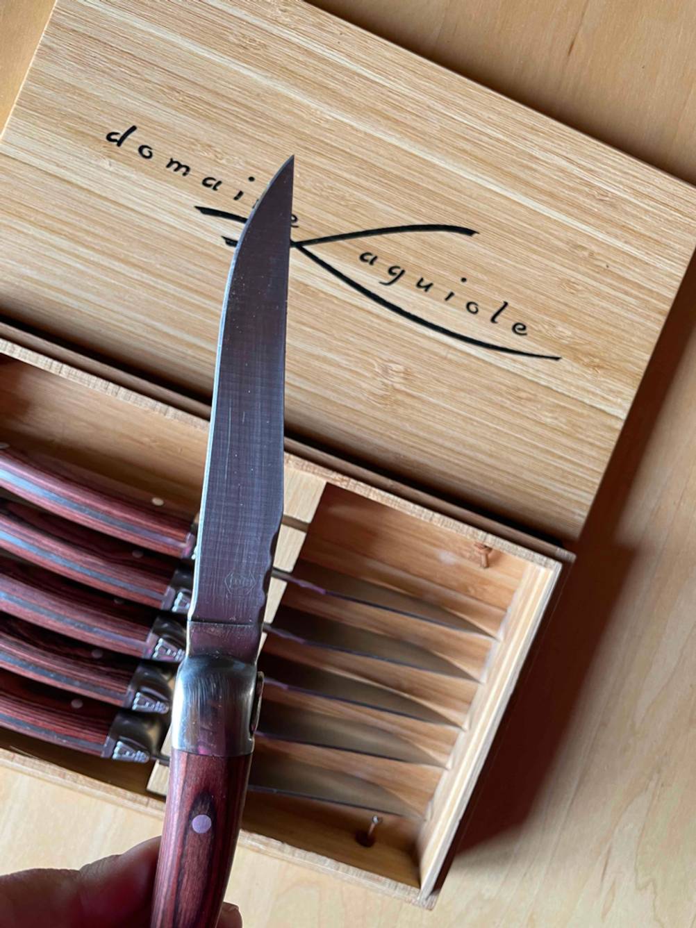 Steakmesser Test: Nahaufnahme der Klinge eines Messers über die Aufbewahrungsbox mit sechs Messern gehalten.