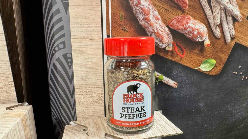 Steakpfeffer getestet: Ein Glas von vorne vor einem Plakat.