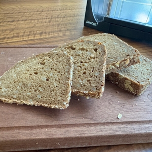 Geschnittenes Vollkornbrot liegt auf einem Holzbrett