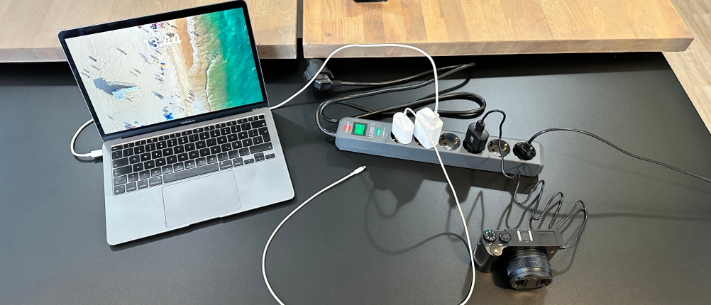 Ein Laptop sowie mehrere Geräte sind mit der Brennenstuhl Eco-Line verbunden und auf dem Tisch verteilt.