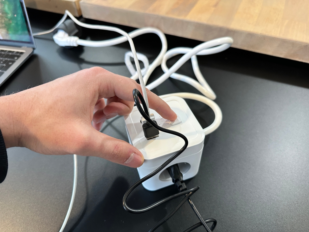 Eine Hand betätigt den Schalter der JSVER-PS3132-Würfelsteckdose.