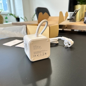 Die ausgepackte JSVER-PS3132-Würfelsteckdose liegt seitlich neben dem geöffneten Karton und der Bedienungsanleitung.