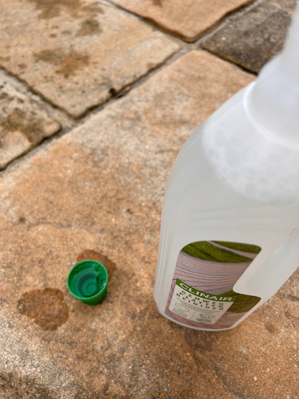 Getestet: Eine Flasche Steinreiniger geöffnet mit der Verschlusskappe daneben.