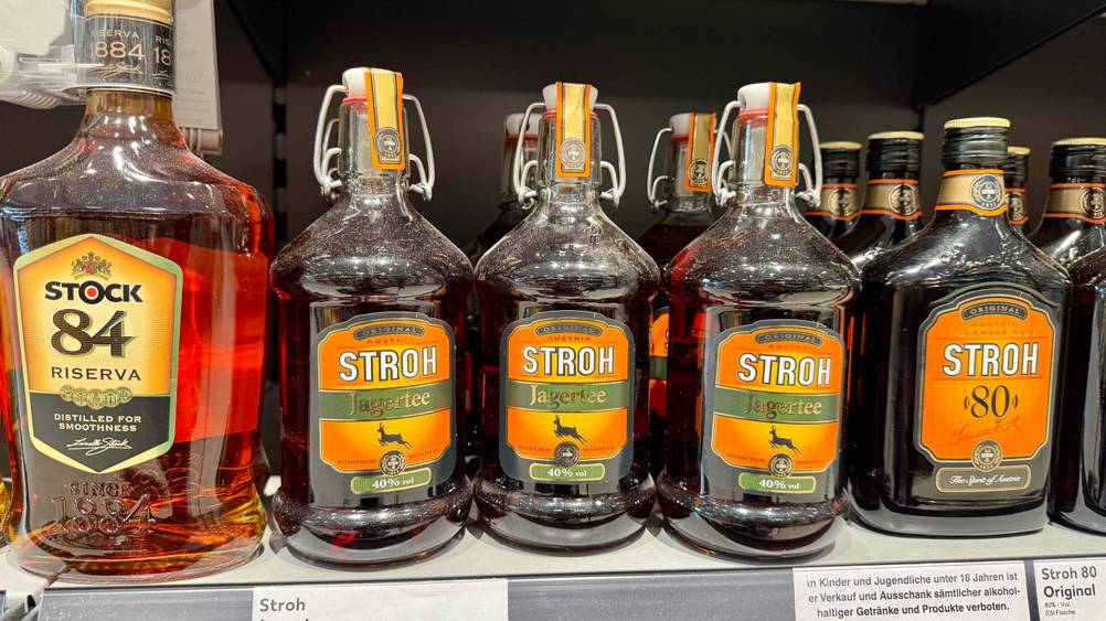 Mehrere Flaschen des getesteten Jagertees stehen neben anderen Produkten in einem Regal.
