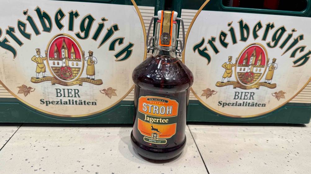 Vor Bierkisten steht eine Flasche Jagertee im Test.