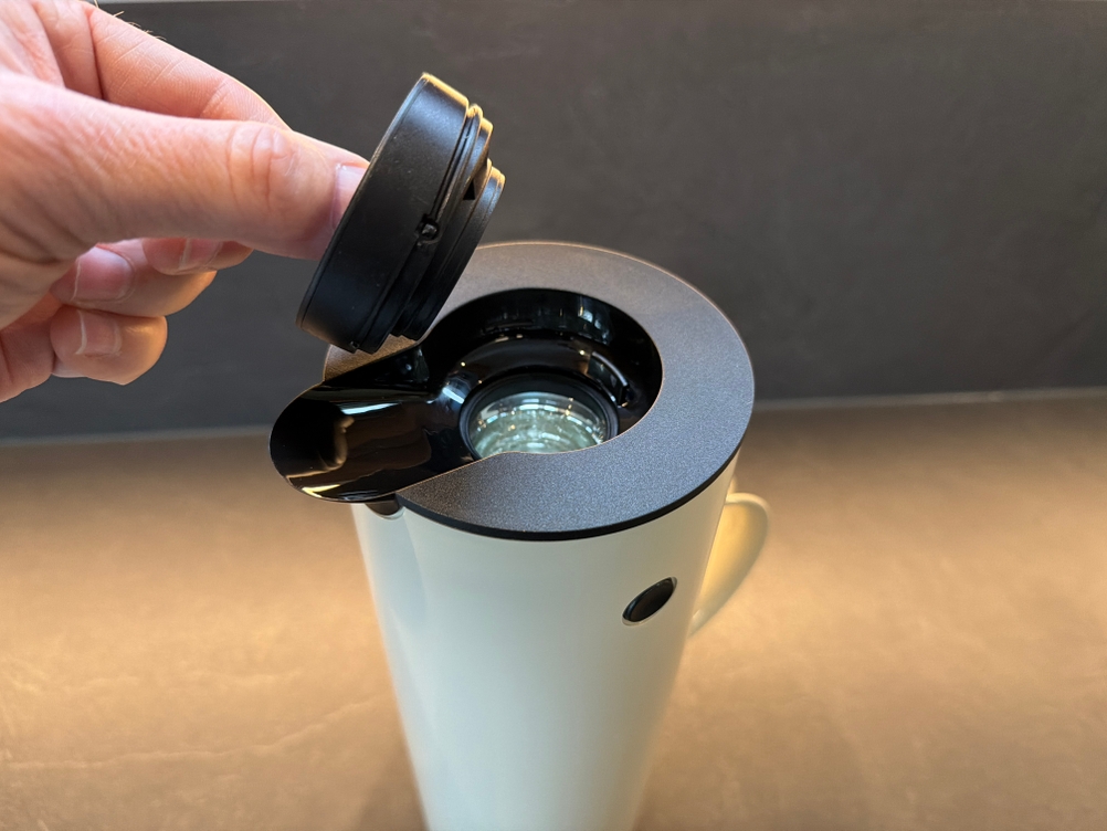 Eine Hand nimmt den Deckel der Stelton EM 77 ab