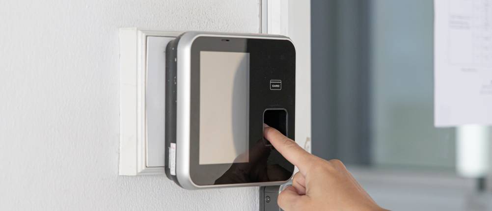 Stempeluhr-Test: Eine Hand bedient eine Stempeluhr mit Fingerprint.