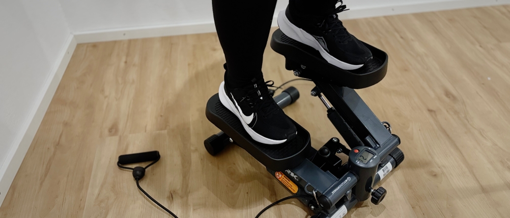 Eine Person steht auf den Pedalen des Steppers und beginnt eine Trainingsbewegung.
