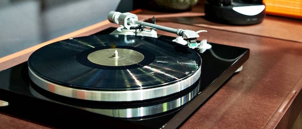 Stereoanlage-mit-Plattenspieler-Test: Nahaufnahme eines Plattenspielers auf einer Holzoberfläche.