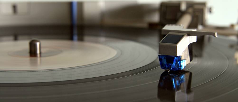 Stereoanlage mit Plattenspieler im Test: Nahaufnahme einer Schallplatte mit einem aufgesetzten Tonkopf.