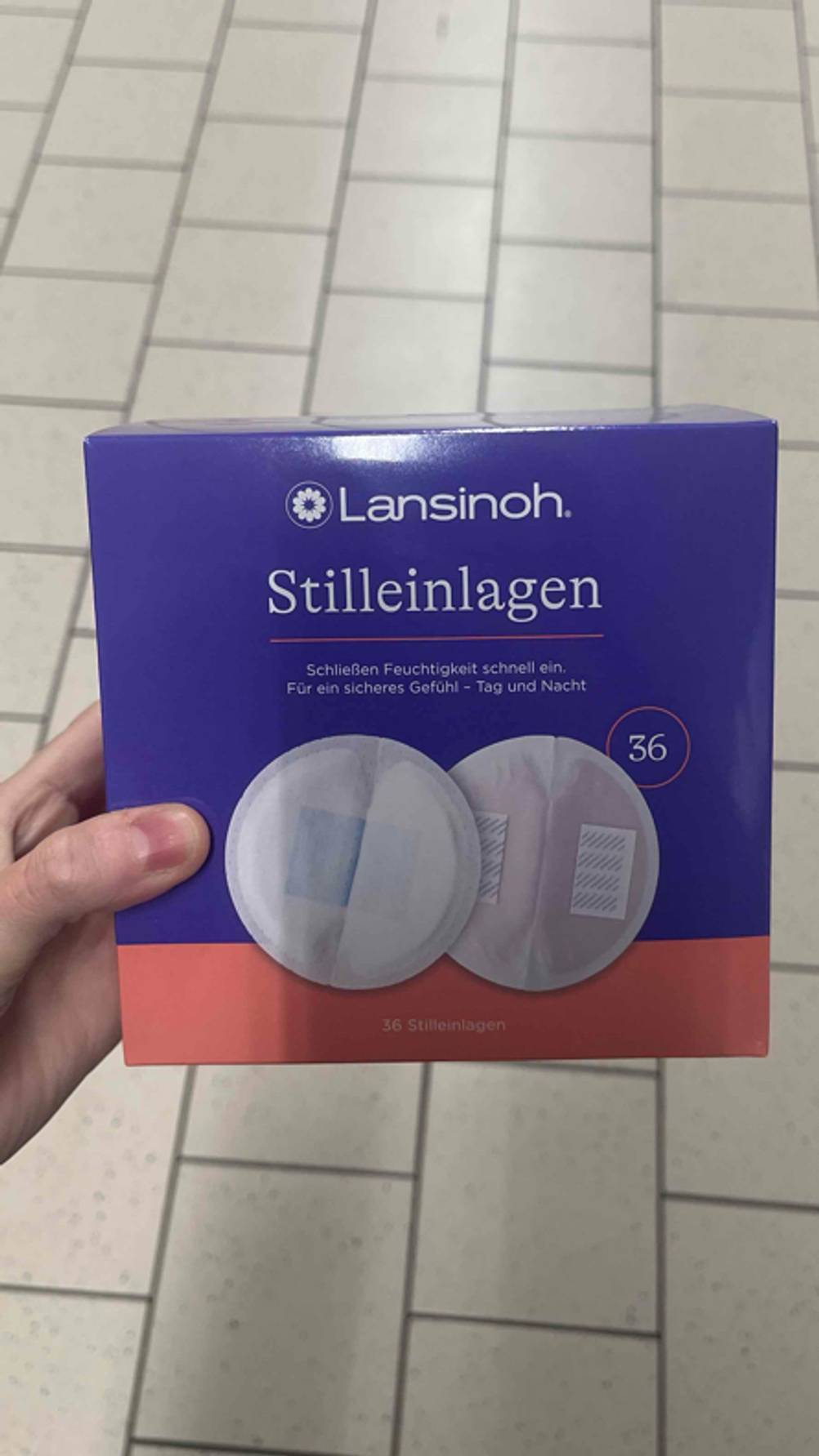 Eine Hand hält eine Packung der getesteten Stilleinlagen hoch.