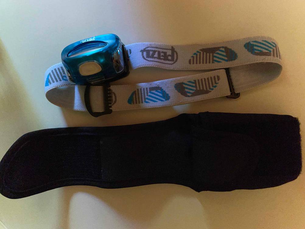 Petzl-Stirnlampen-Test: Eine Stirnlampe von Petzl liegt neben einer Aufbewahrungstasche. 