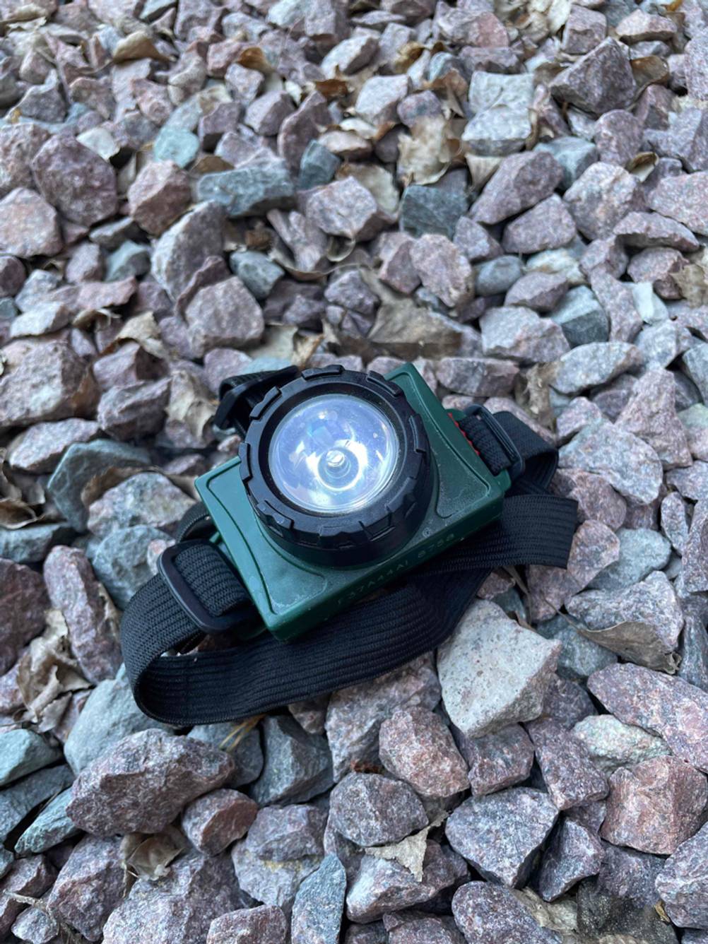 Stirnlampe (Kinder) getestet: Die Lampe liegt auf Steinen mit der Leute nach oben.