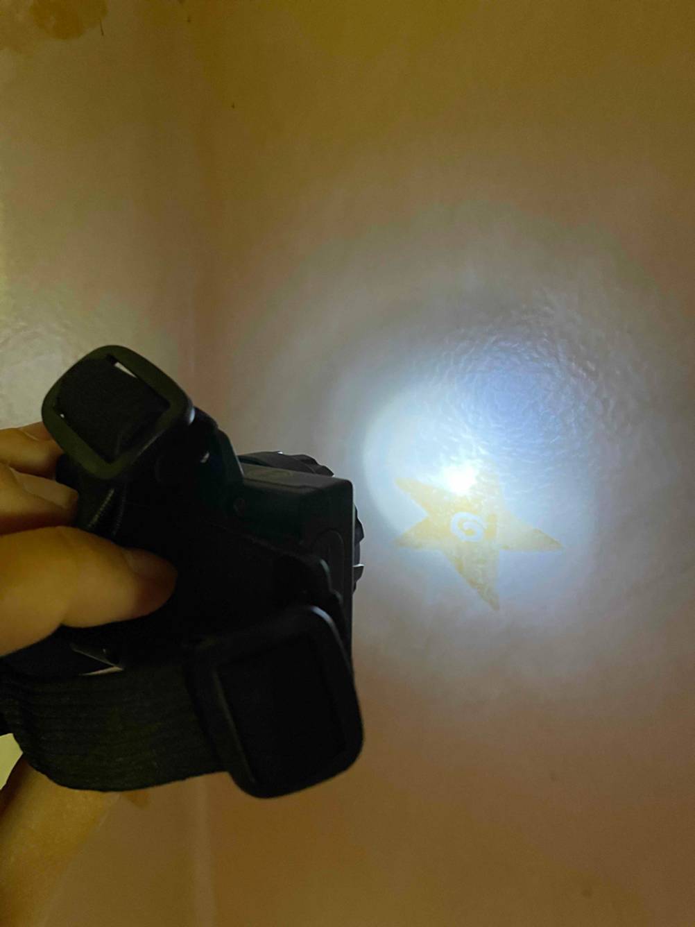 Kinder-Stirnlampen-Test: Stirnlampe leuchtet gegen eine Wand. 