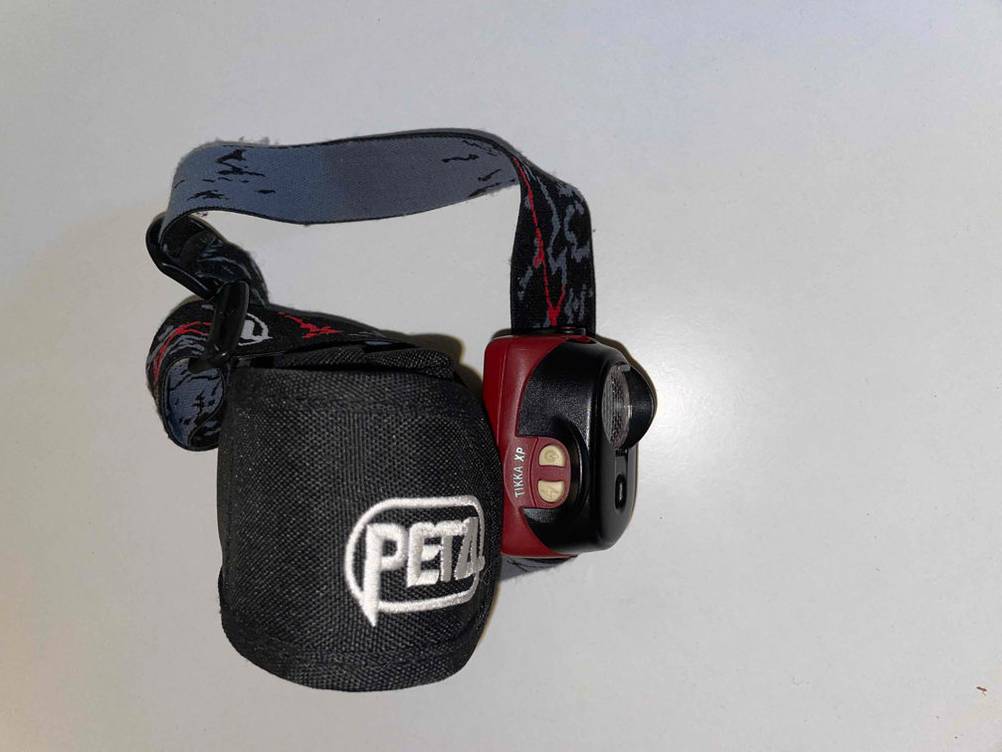 Petzl-Stirnlampen-Test: Eine Stirnlampe von Petzl und eine Aufbewahrungstasche von Petzl. 