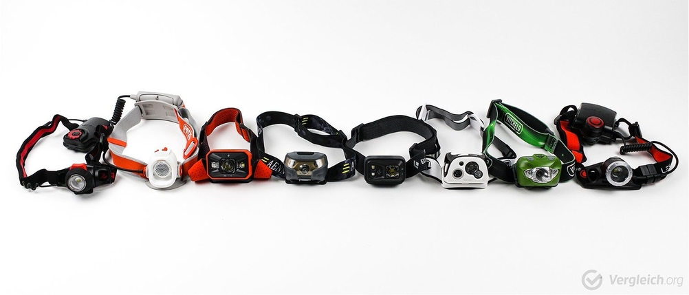 Verschiedene Stirnlampen im Test liegen nebeneinander.