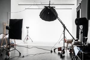 Stockfotos im Test: Ein leeres Fotostudio mit mehreren Lichtformern und einem weißen Hintergrundsystem.