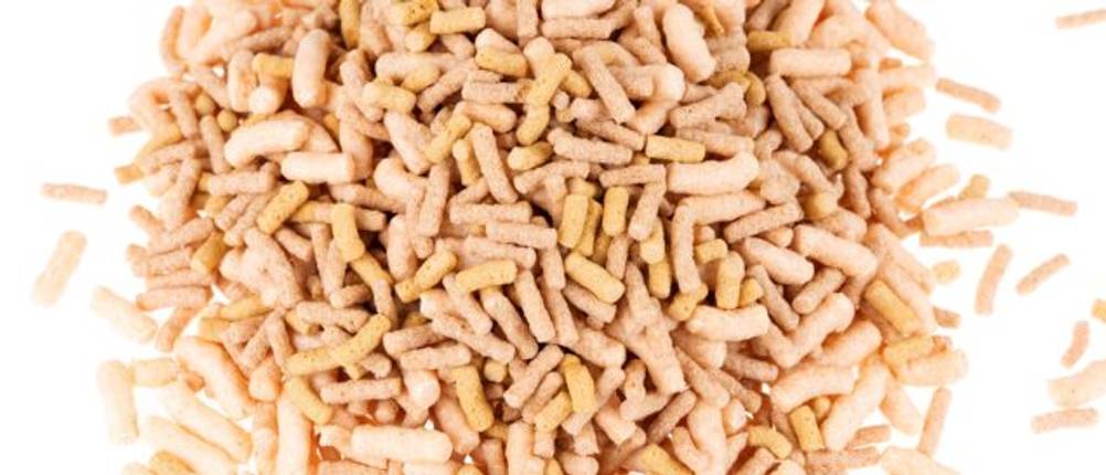 Störfutter-Test: Fischfutter-Pellets auf einem weißen Untergrund. 