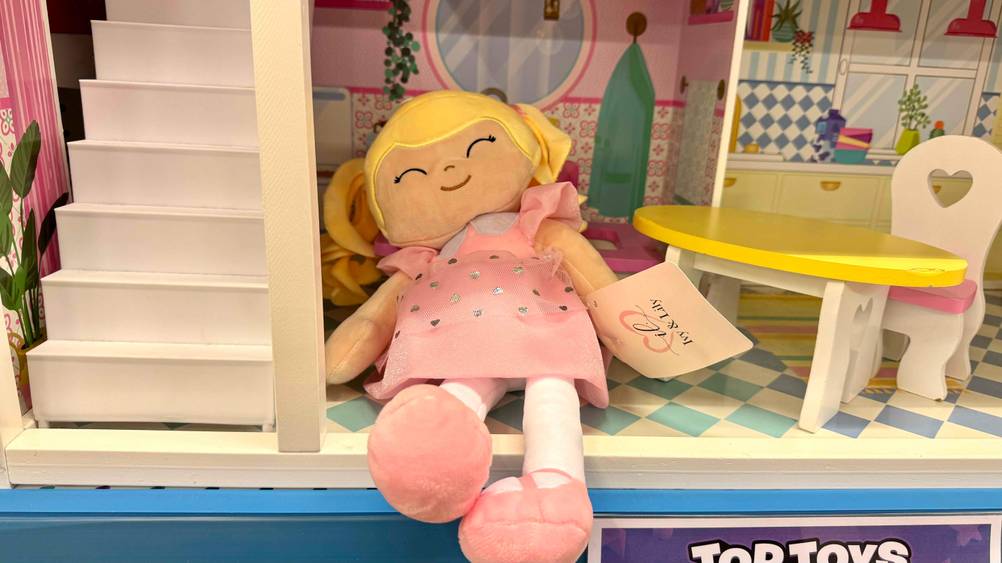 Getestet: Die Stoffpuppe liegt in einem Puppenhaus.