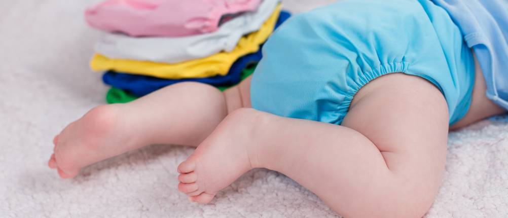 Stoffwindeln-Test: Ein Baby krabbelt auf einem weichen Untergrund, während es eine Stoffwindel trägt.