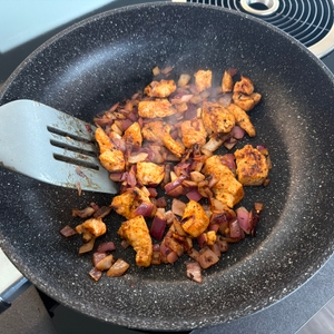 Fleisch und Zwiebeln werden in der Stoneline 19512 mit einem Pfannenwender vermischt