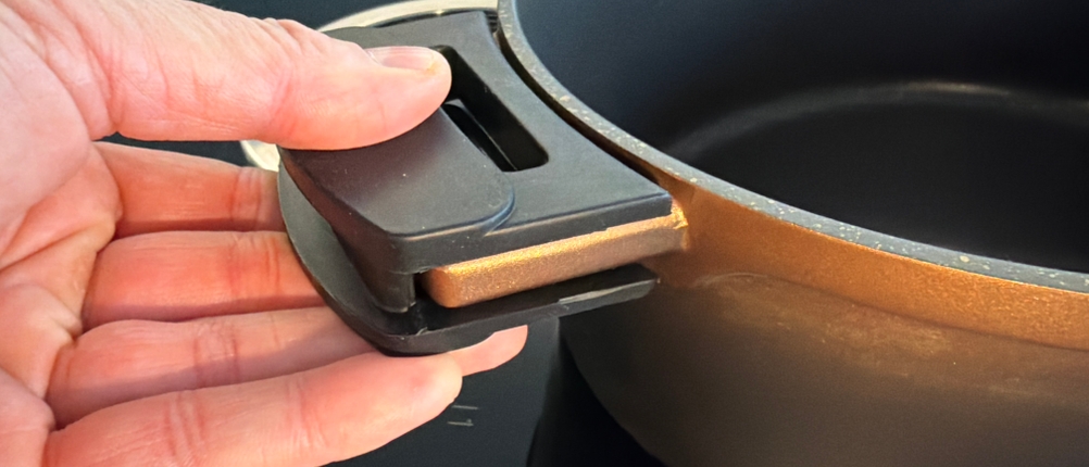 Eine Hand hält den Stoneline Cocotte am Silikongriff fest