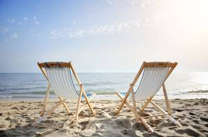 niedrige strandstühle am strand bei sonnenuntergang
