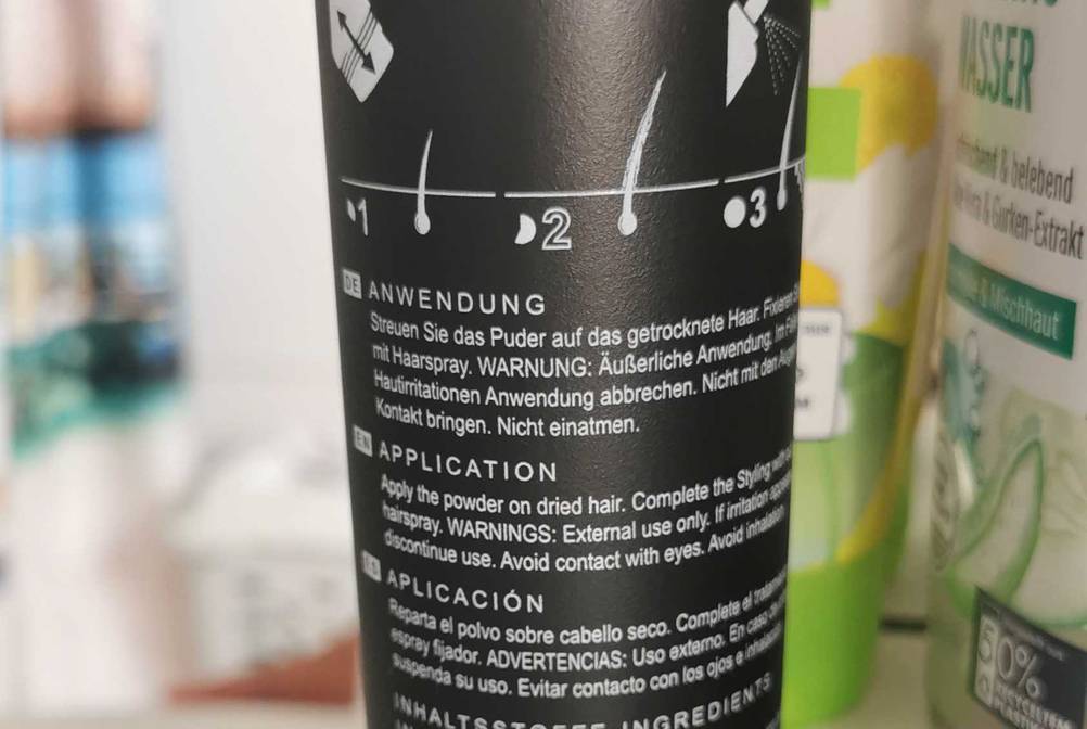 Nahaufnahme der Rückseite der Dose des Streuhaars im Test mit Anwendungserklärung.