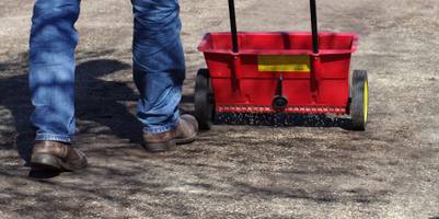 Ein Streuwagen, mit dem Rasen auf Erde ausgesäht wird.