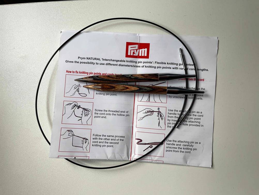 Die getesteten Stricknadeln liegen auf einer Bedienungsanleitung.