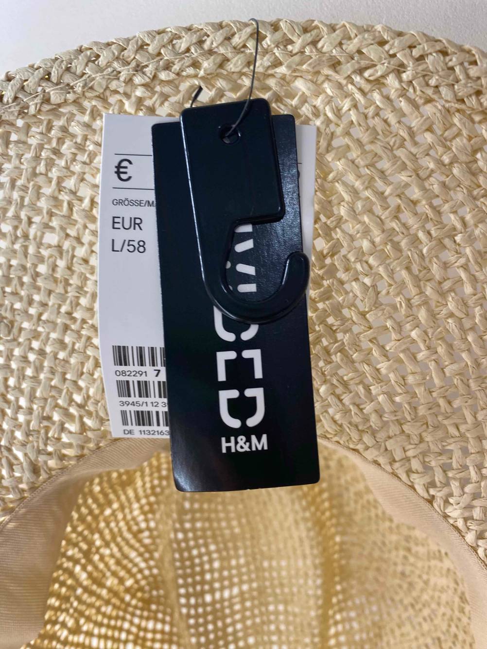 Preis-Größen-Label in Nahaufnahme an einem getesteten Strohhut für Damen.
