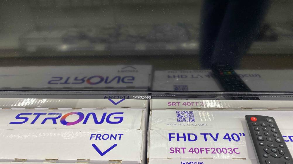 40-Zoll-Fernseher-Test: Nahaufnahme des Logos am unteren Rahmen inklusive Fernbedienung.