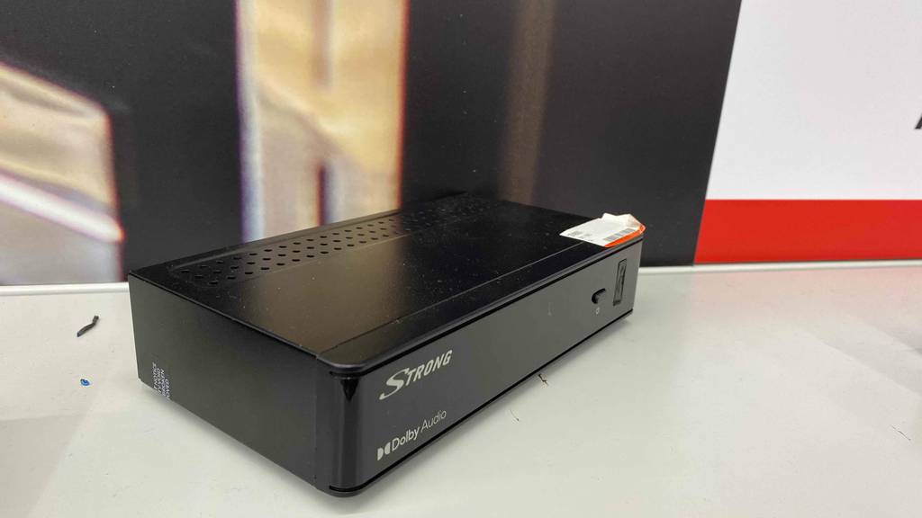 Im Test: Ein DVB-T Receiver steht auf einem weißen Regal, von der Seite betrachtet.