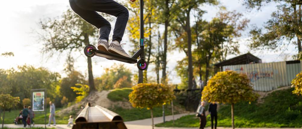 Stunt-Scooter-Test: Junge, der mit seinem Scooter einen Sprung über eine Halfpipe macht