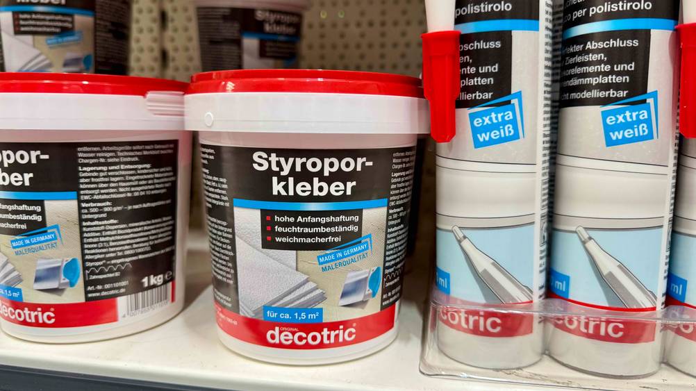 Mehrere Dosen des Styroporklebers im Test in einem Verkaufsregal neben anderen Produkten.