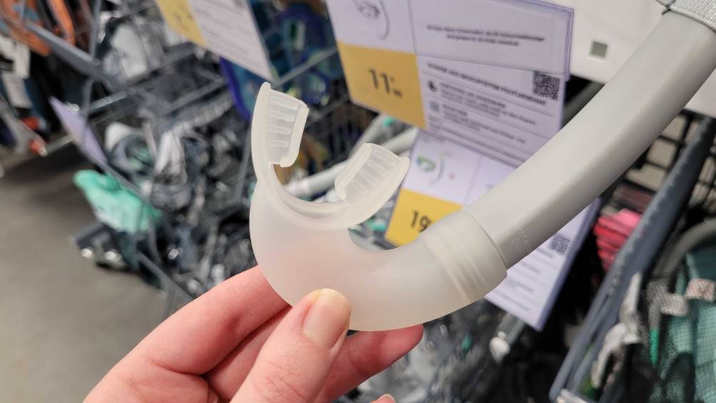 Schnorchelset-Kinder-Test: Detailansicht eines hellen, semitransparenten Mundstücks aus Silikon vor einem Verkaufsregal.