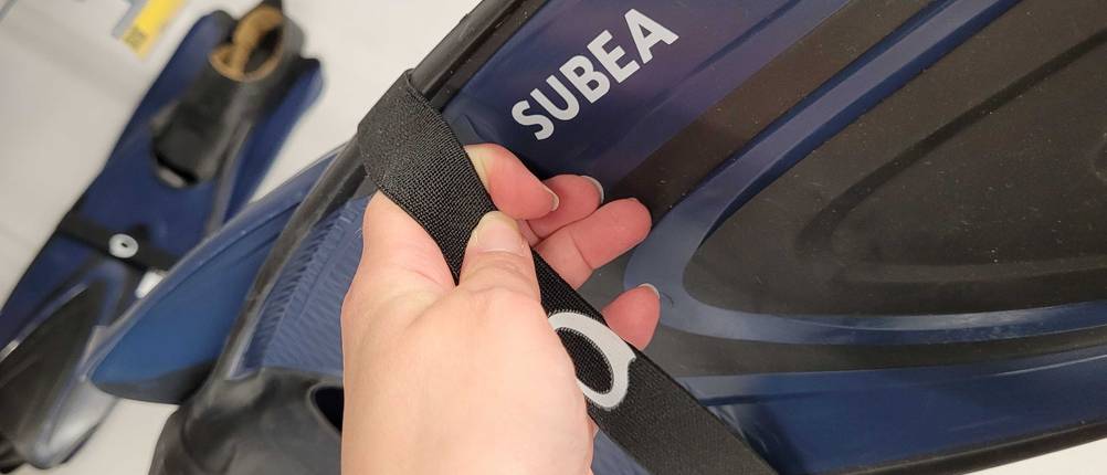 Schwimmflossen im Test: eine Hand hält den Klettverschluss von Schwimmflossen der Marke SUBEA