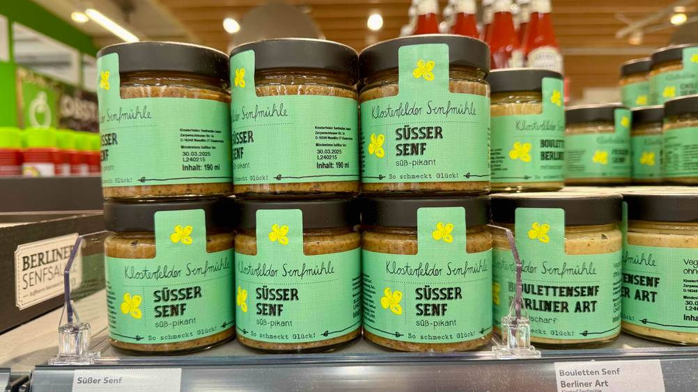 Mehrere Gläser des süßen Senfes im Test auf einem Verkaufsregal.