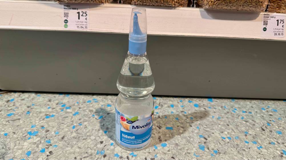 Vor einem Verkaufsregal mit Preisangaben steht der getestete Süßstoff.