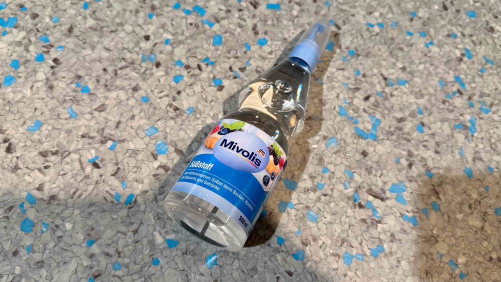 Auf einem grauen Boden liegt eine Flasche des Süßstoffes im Test.