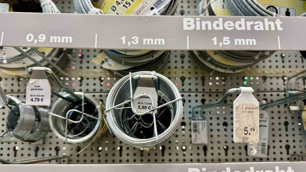 Bindedraht im Test: Mehrere Rollen unterschiedlicher Größen hängen in einem Regal.