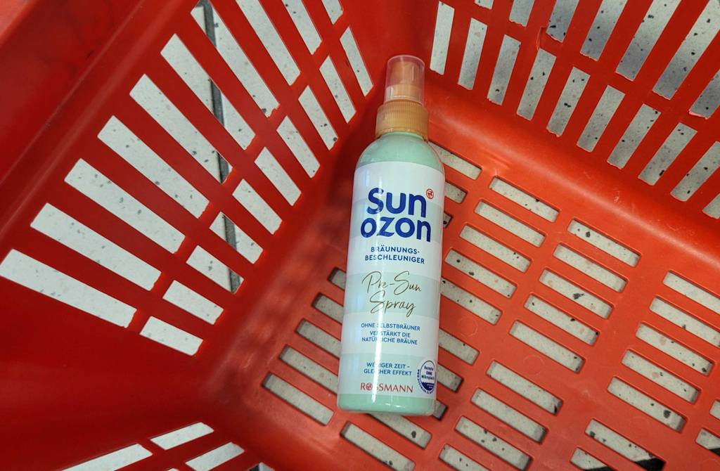 Eine hellgrüne Sprühdose mit Sun Ozon Bräunungsbeschleuniger im Test liegt in einem roten Einkaufskorb.
