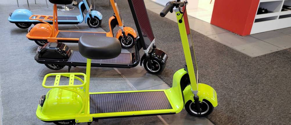 Elektro-Scooter im Test: mehrere Scooter in verschiedenen Farben schräg hintereinander aufgereiht