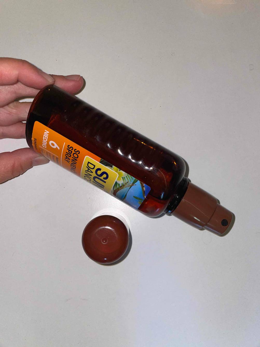 Sundance Sonnenöl-Spray von der Seite mit geöffnetem Deckel.