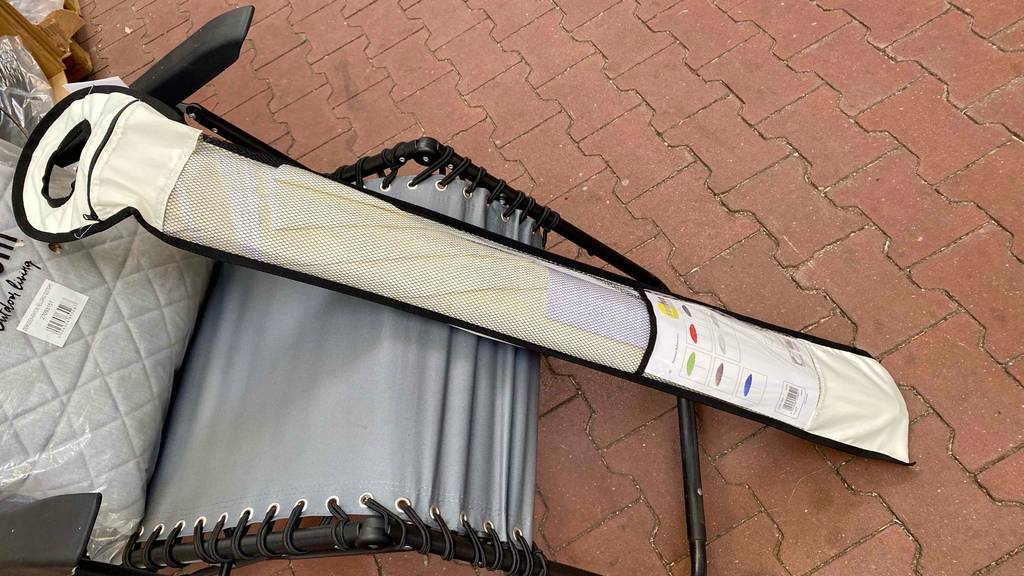 Im Test: Ein Sonnenschirm mit 200 cm in seiner Verpackung lehnt an einen Liegestuhl.