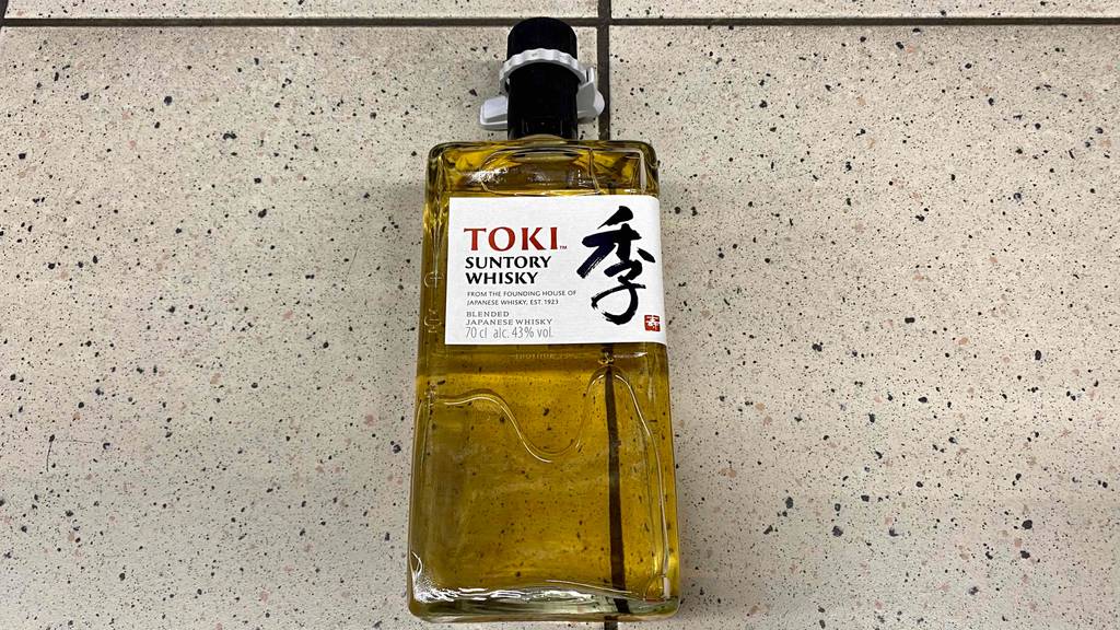 Die getestete Flasche Suntory Toki Whisky liegt auf dem Fliesenboden.
