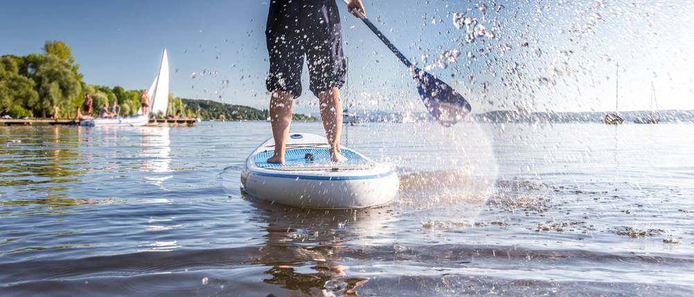 SUP-Paddel-Test: Person paddelt auf einem SUP-Board auf einem See.