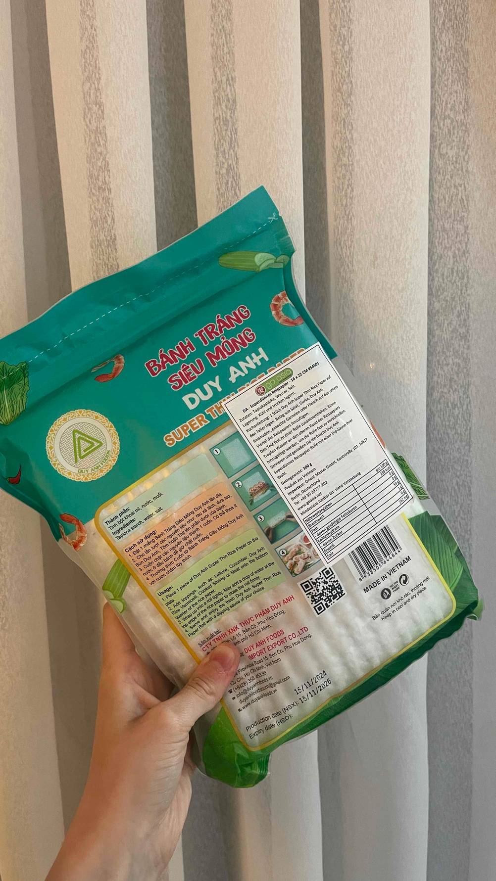 Die Verpackung mit dem getesteten Reispapier befindet sich in einer Hand vor einem hellen Vorhang.